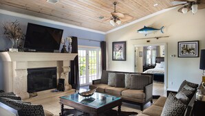 A spacious living room with a fireplace, comfortable seating, and a television. - LUXURY WATERFRONT ESTATE SEAWALL DOCKAGE & POOL (Key West)