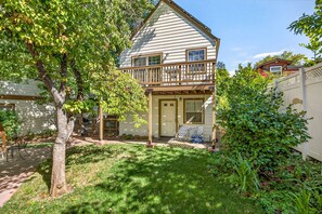 A two-story house with a front porch, a covered patio, and a small deck.