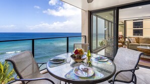 A balcony with a glass table set for dining, overlooking the ocean. - Spectacular Oceanfront, 270 Degree Views, Amazing Sunsets & Sea Life,Lanai tower (Lahaina)