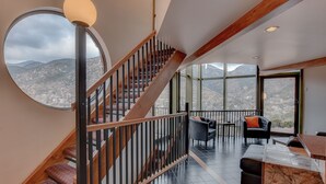 Un ambiente spazioso con una scala che conduce a un balcone con vista sulla città.