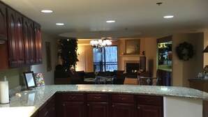 A spacious kitchen with a granite countertop, wooden cabinets, and a large island.
