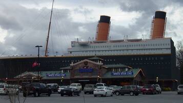 A large building with two prominent smokestacks, a flagpole with an American flag, and signage for 'White Star Line' and 'White Star Line Hotel'.