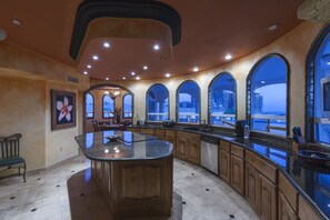 Enjoy cooking in this well-equipped kitchen with a central island, dishwasher, and coffee maker, offering a view of the surrounding landscape.
