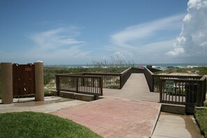 Walk along the boardwalk to the beach, where umbrellas and beachgoers await.