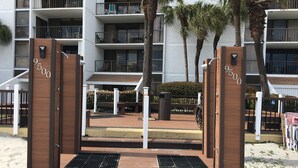 A beachfront hotel entrance with a wooden gate, numbered 9500, leading to a sandy area. - Ocean Front-BRIGADUNE 14E Paradise on Shore Drive Family friendly  (Myrtle Beach)
