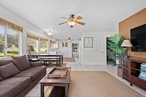 A spacious living room with a sofa, coffee table, and a television.