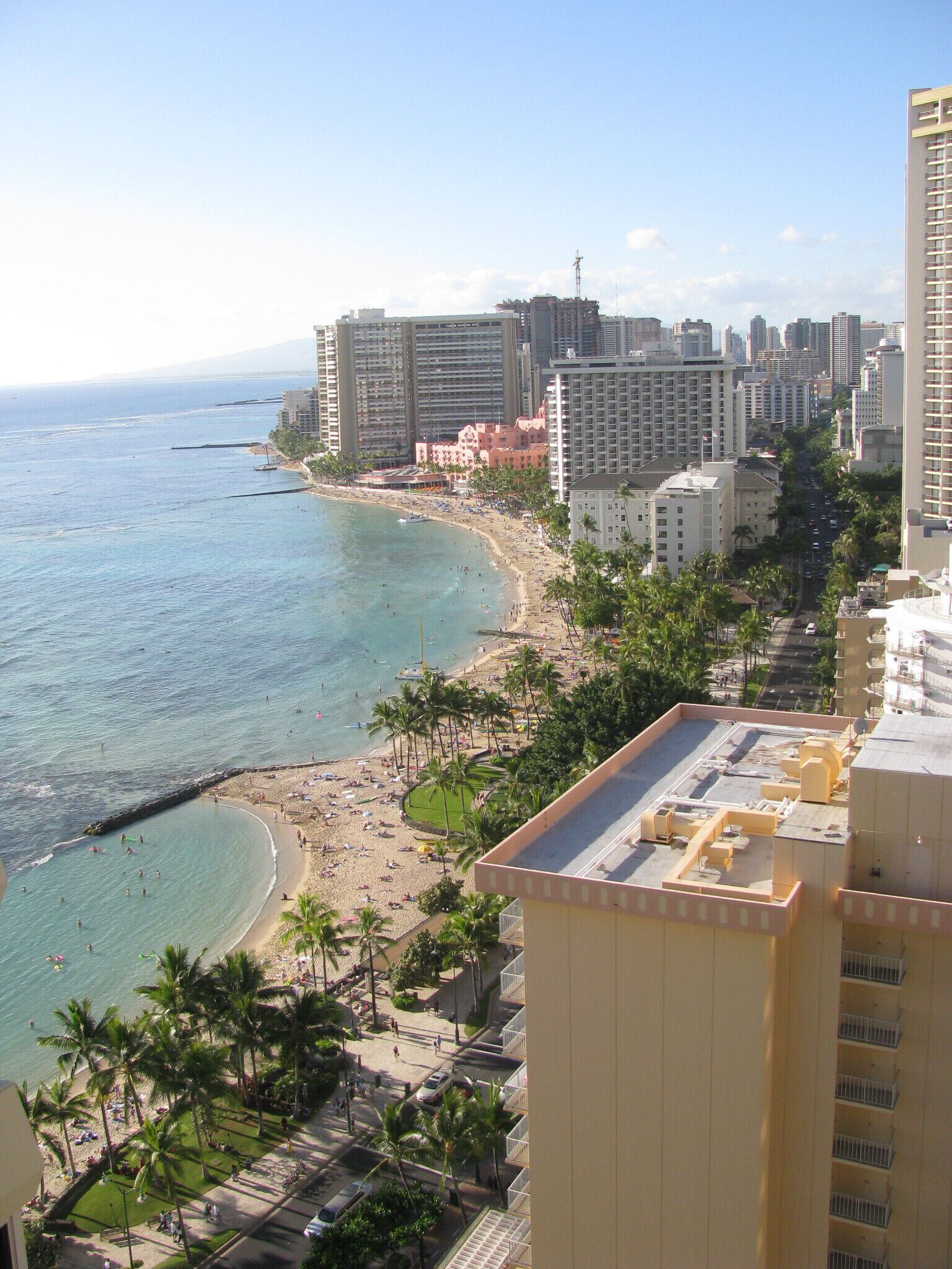 A coastal cityscape with a beach, high-rise buildings, and a clear sky.