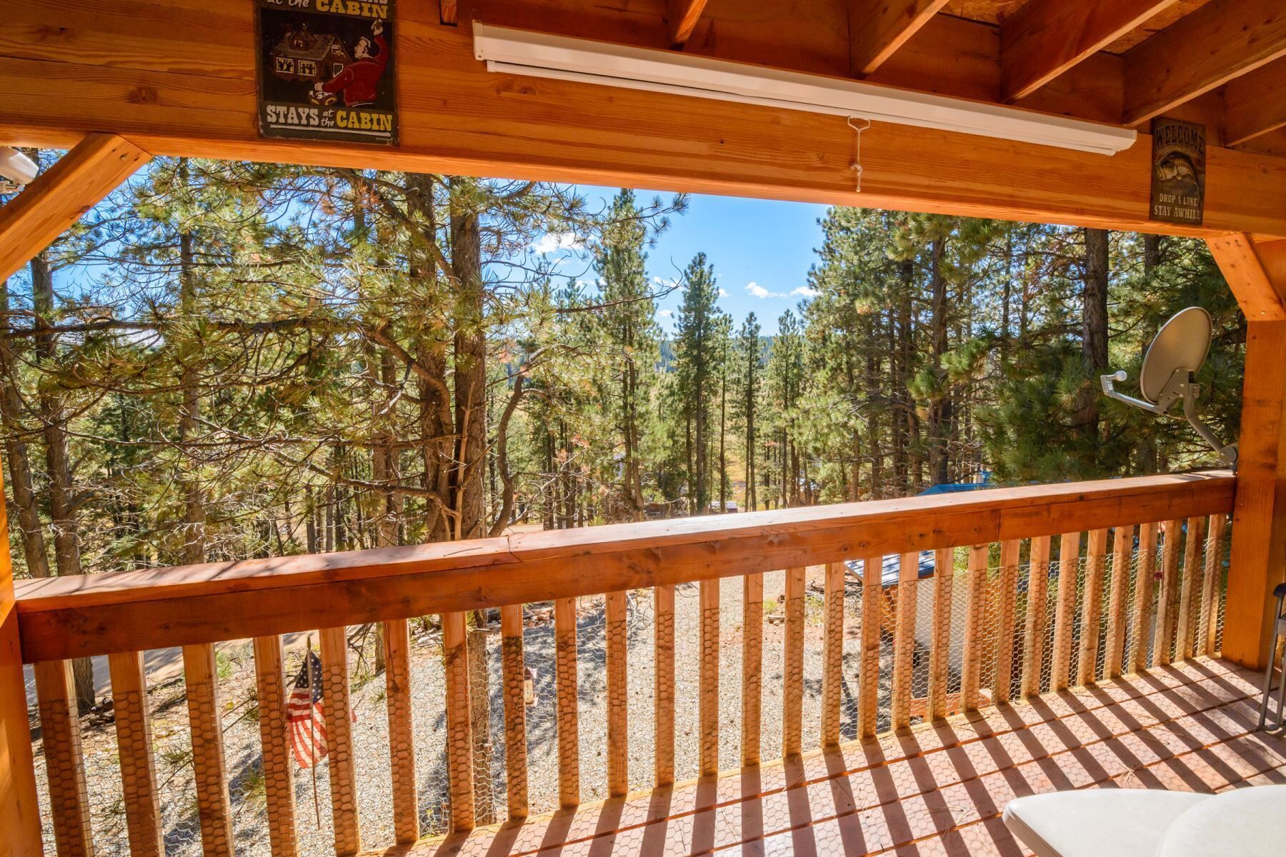 A wooden deck with a view of a forest.