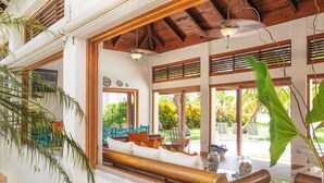 A spacious living area with a wooden bench, a sofa, and a table with decorative items.