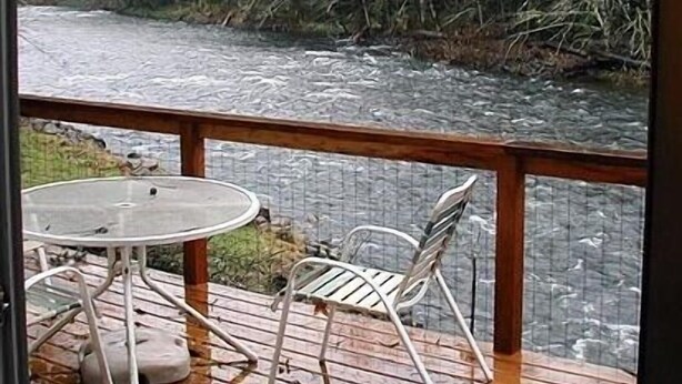 A deck with a table and chairs overlooking a river. - Relaxing Getaway on Mt Hood - Right on the River! (Mount Hood Village)