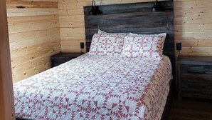 A wooden cabin bedroom with a bed, two bedside tables, and a headboard. - Kia'a'yo Bear Cabin -- Modern Cabin -- 15 Min to Glacier East Entrance (Babb)