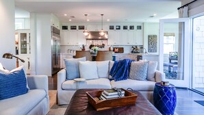 A modern living room with a sofa, coffee table, and a kitchen in the background.