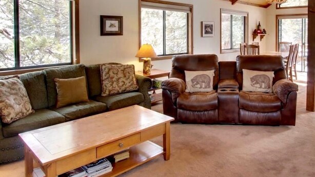 A spacious living room with a high wooden ceiling, large windows, a leather sofa, a wooden coffee table, and a fireplace. - Family-Friendly, Pet-Friendly, Tree-Surrounded Tahoe City Vacation Home (Tahoe City)