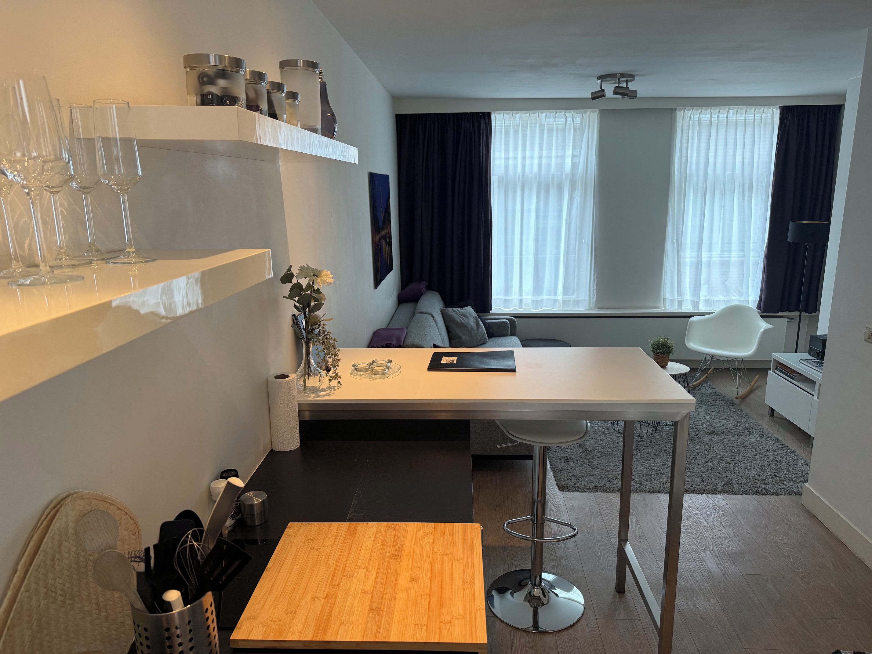Un salon moderne comprenant un canapé, une table basse et un coin repas avec une table et des chaises.