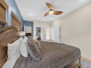 A bedroom with a large bed, a ceiling fan, and a door leading to another room. - Slopes Loft | Walk to Giant Steps Ski Lifts (Brian Head)