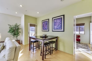 Cozy living space with a dining area, featuring a wooden table and chairs, and a small potted plant.