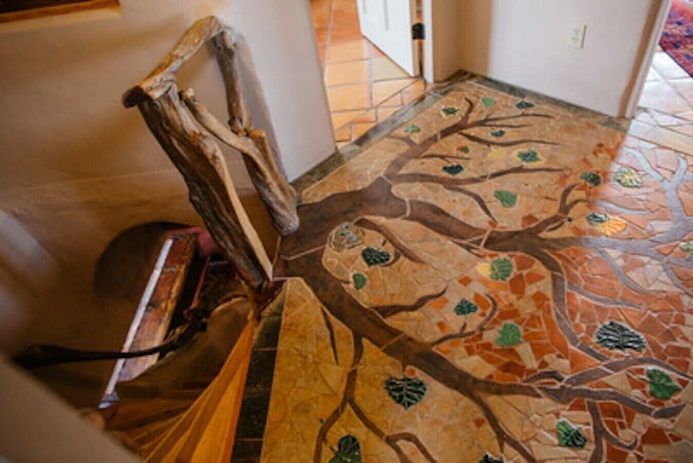 Une pièce dont le sol est recouvert de carreaux formant une mosaïque représentant un arbre.