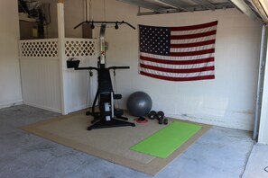 A home gym with exercise equipment, a green mat, and an American flag on the wall. - Dog friendly! Super Quiet, Pool, Close to Disney, Indoor Game Room, 2 Masters (Davenport)