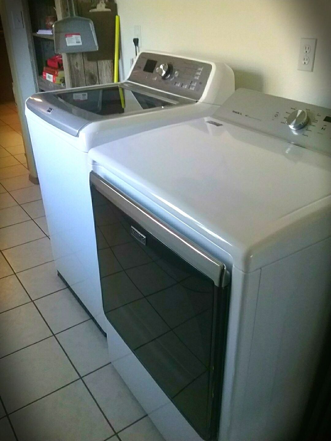 Eine Waschmaschine und ein Trockner mit Bedienfeld, in einem Raum mit Fliesenboden.