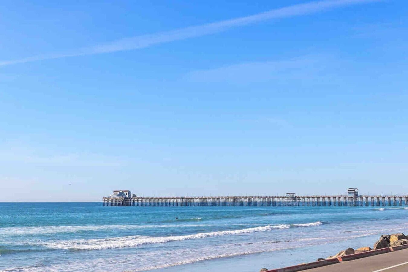 A pier extending into the ocean with a clear sky above.