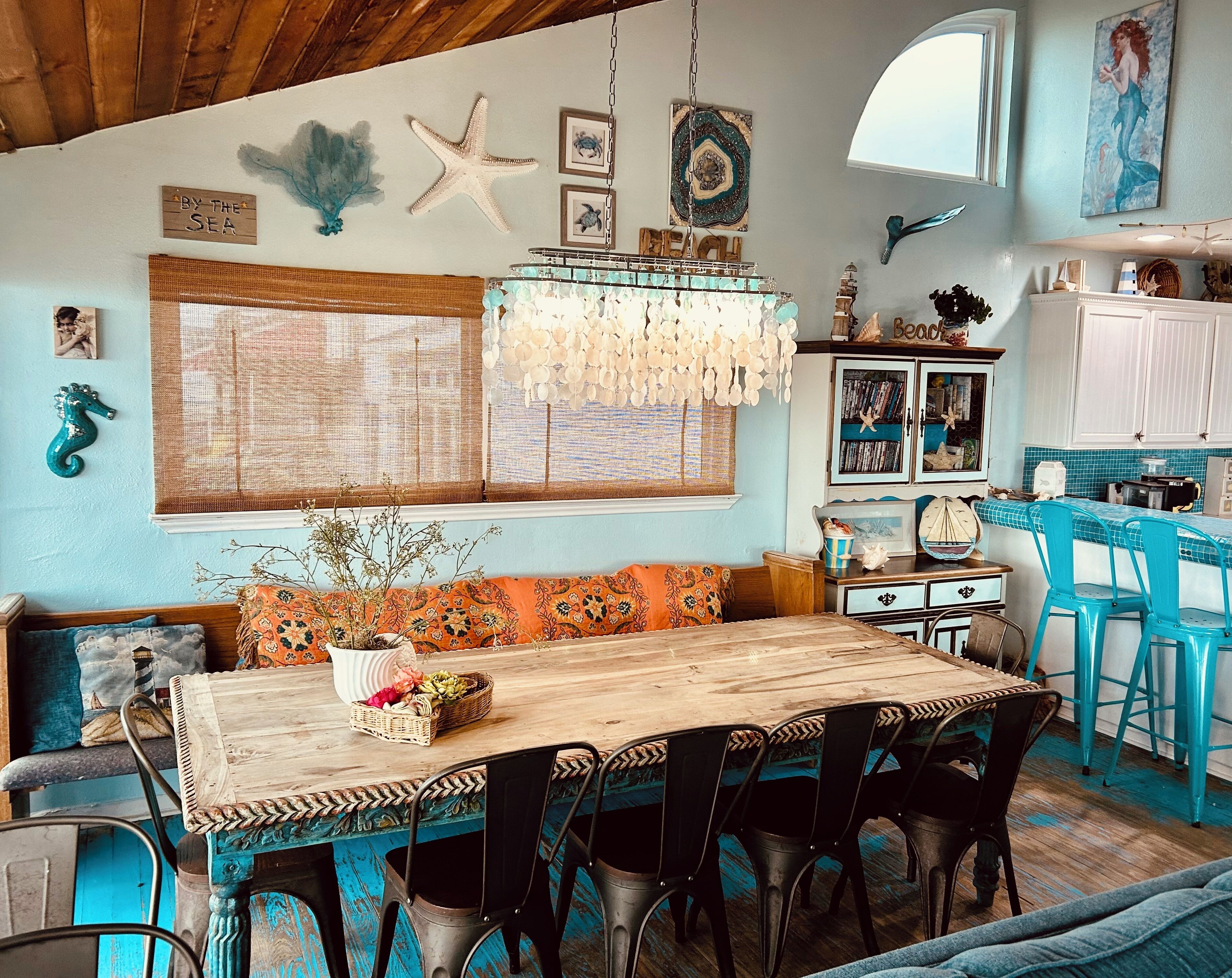 Un coin repas avec une table en bois, des chaises et un lustre.