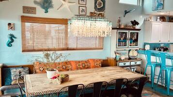 Un coin repas avec une table en bois, des chaises et un lustre.