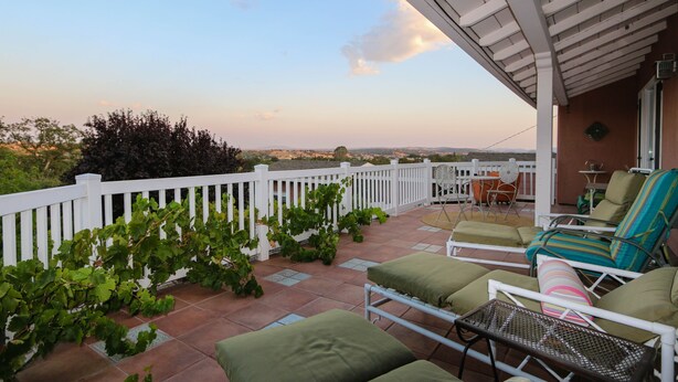 A terrace with outdoor seating, a white fence, and a view of the landscape. - Treetop Lodge - Lose yourself in the views on the westside, close to downtown. (Paso Robles)