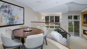 A dining area with a round table, six chairs, and a painting on the wall. - Coldstream Townhome 38 | Stylish 3BR Cascade Village Retreat (Vail)