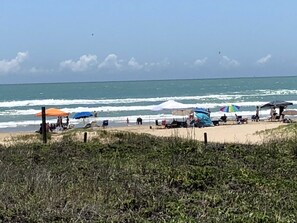 A beach with umbrellas and people.