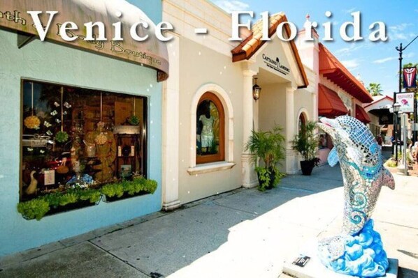 Une devanture de magasin avec une enseigne indiquant « Venise – Boutique de Floride » et une sculpture décorative représentant un cheval.