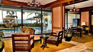 A lobby with a pool view, comfortable seating, and a large vase. - Beachfront Paradise, Stunning Views, Condo with AC, Steps to the beach! (Lahaina)