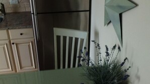 Una cocina con un refrigerador de acero inoxidable, una silla blanca y una estrella decorativa en la pared.