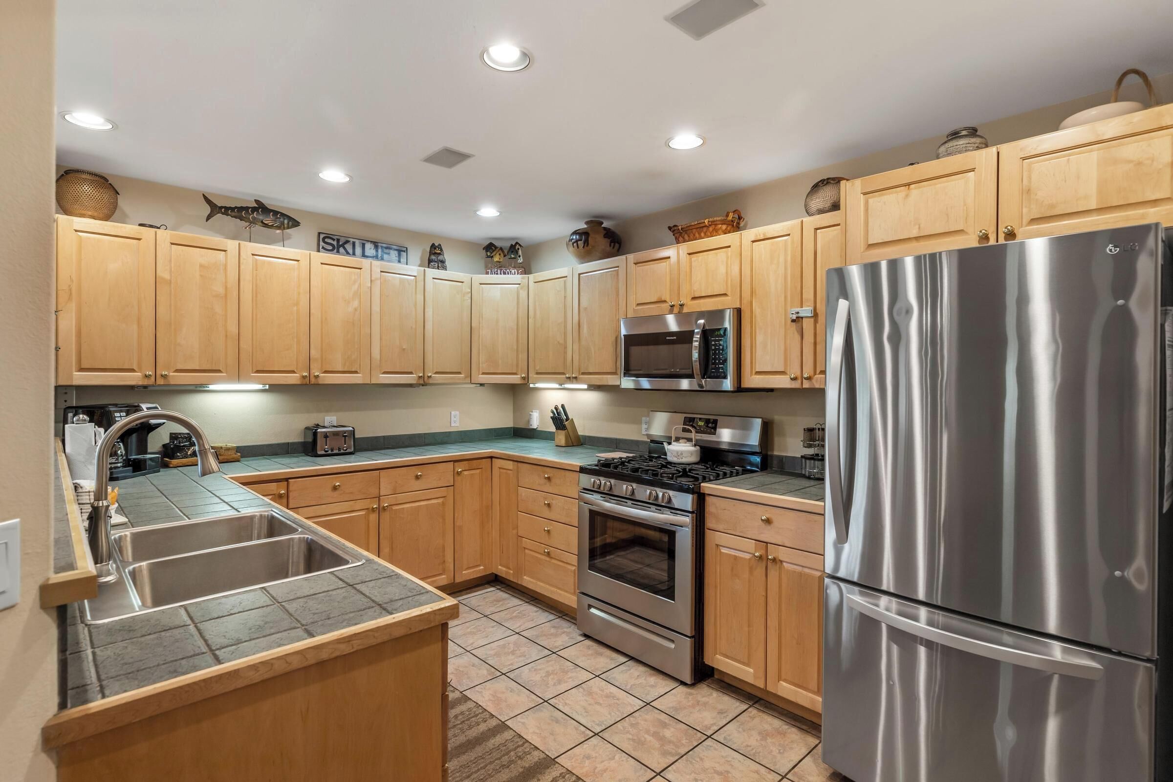 A modern kitchen with wooden cabinets, stainless steel appliances, and a tiled backsplash.