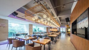 Un restaurant moderne avec un long comptoir, de nombreuses tables et des chaises.