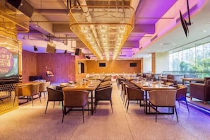 A spacious restaurant with high ceilings, modern lighting fixtures, and a view of the outdoors. - Rong Impression International Hotel (Chengdu)