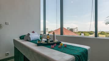 Enjoy a city view from the comfort of this room, featuring a bed, a tray with candles and decorative items, and a potted plant.