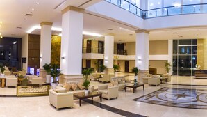 A spacious lobby with a central reception desk, multiple seating areas, and a decorative floor pattern. - Sunrise Hotel (Tan Ninh)