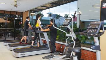 A gym with treadmills, a stationary bike, and a rowing machine.