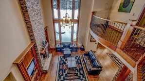 A spacious living area with a large rug, leather sofas, and a chandelier. - 12th Manor in Suncadia (Cle Elum)