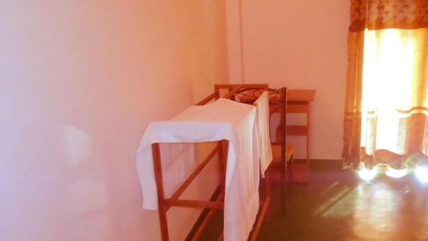 A room with bunk beds, a wooden table, and a window with curtains. - Talalla Sea Anemone Hotel (Talalla)