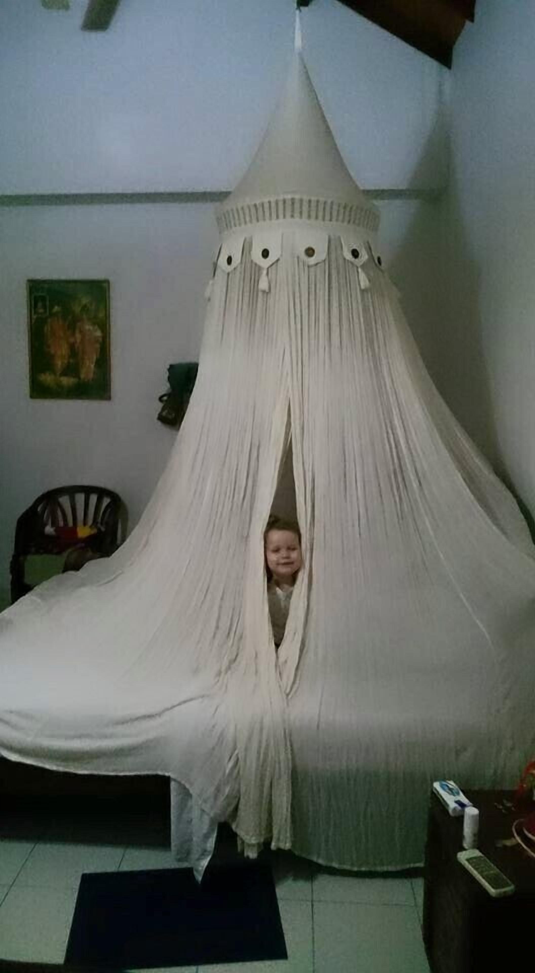 A room with a canopy bed, a chair, and a painting on the wall.