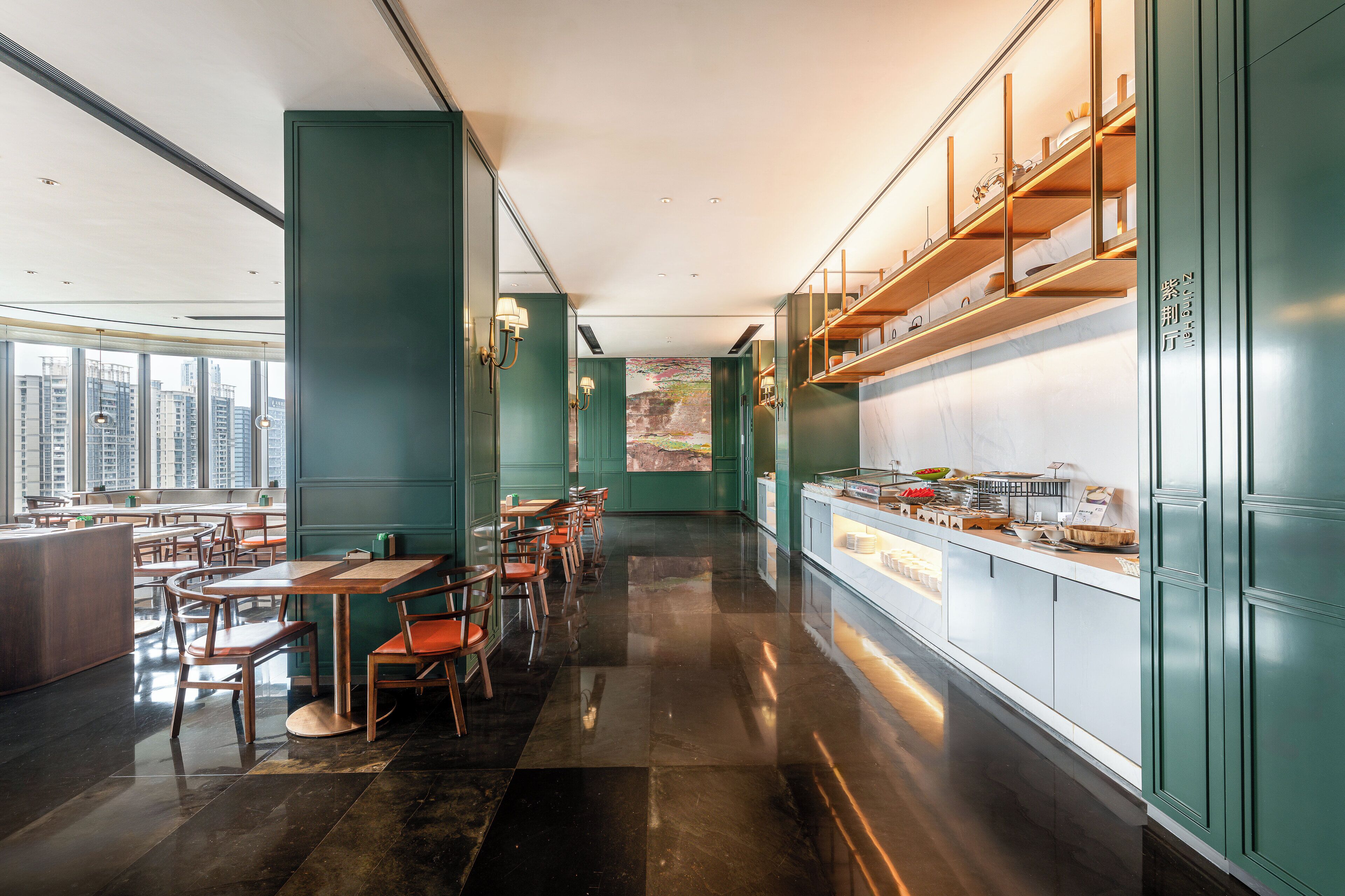 A modern restaurant with high ceilings, a long counter, and a view of the city.