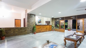 A hotel lobby with a reception desk, seating area, and potted plants. - Siddhartha Resort, Chisapani (Lamki Chuha)