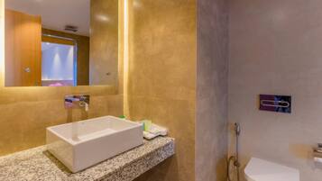A modern bathroom with a rectangular sink, a toilet, and a shower area.