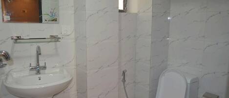Baño con lavamanos, espejo y retrete blanco.