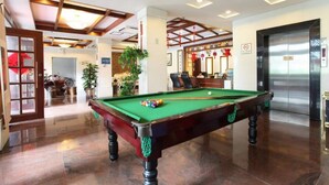 A billiards table in a well-lit room with a ceiling fan, a reception desk, and an elevator. - Guangzhou Conghua Yincheng Hotel (Guangzhou)
