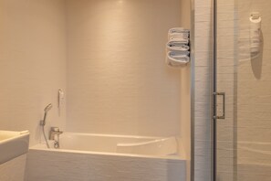 Driepersoonskamer | Badkamer | Een douche, een haardroger, handdoeken