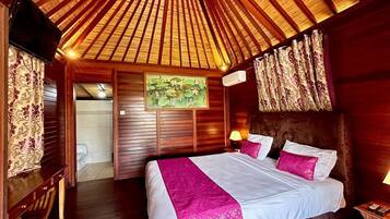 Quarto com teto de madeira, cama com roupa de cama branca e rosa, um quadro na parede e porta de madeira.