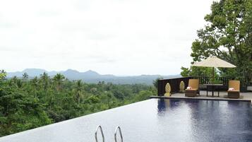 Una piscina infinita con vistas a montañas y vegetación exuberante.