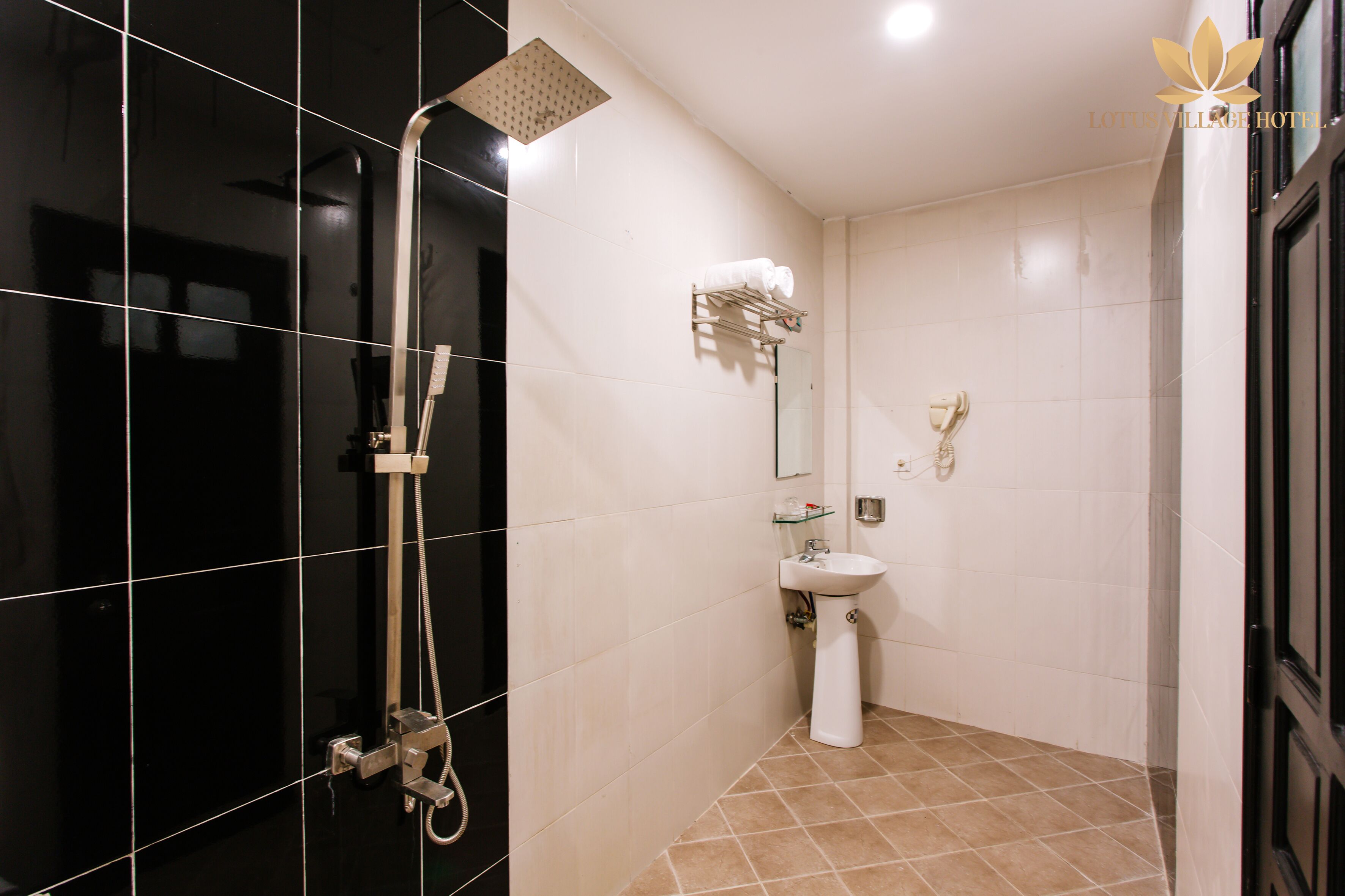 A modern bathroom with a shower, sink, and towel rack.